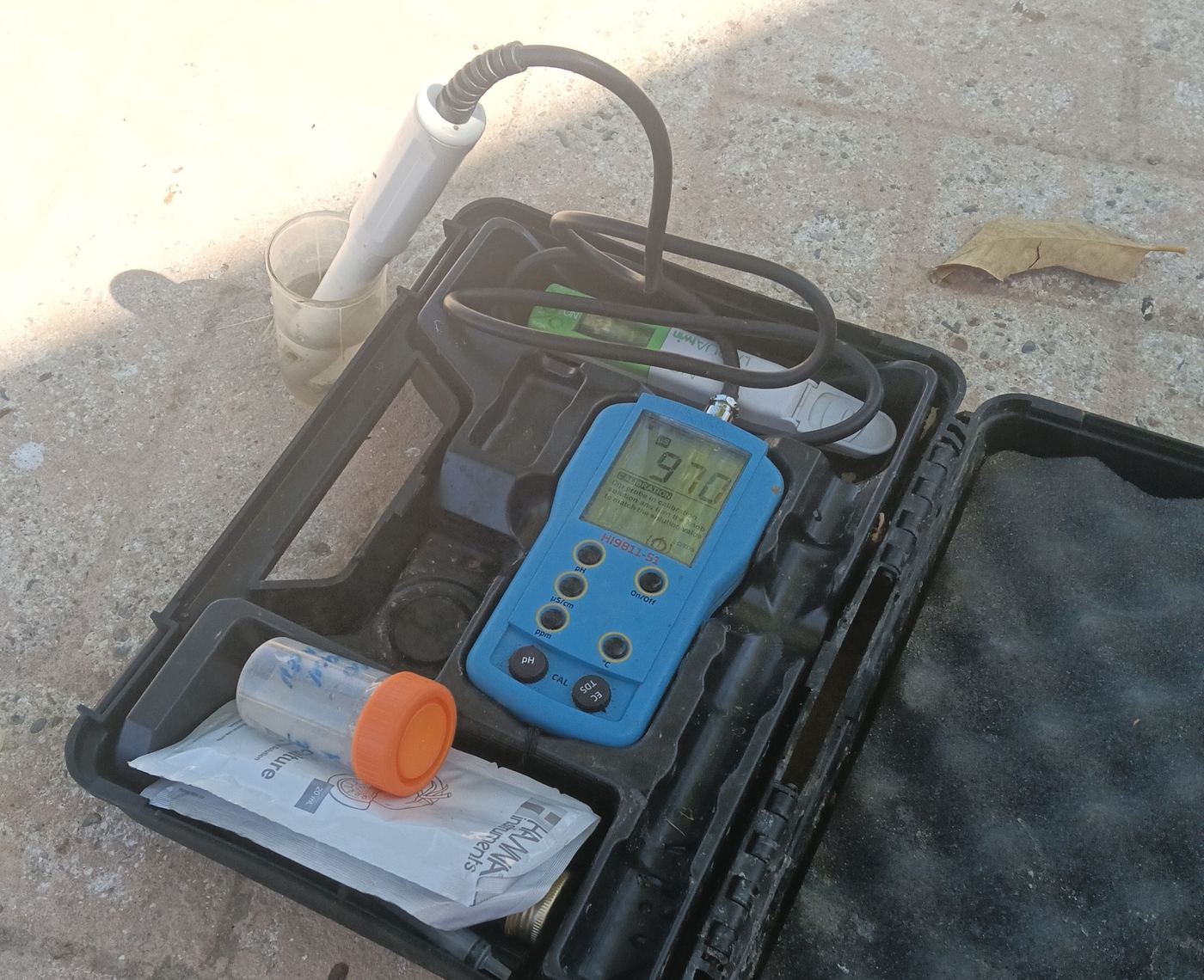 Conductivímetro de campo midiendo una muestra de agua